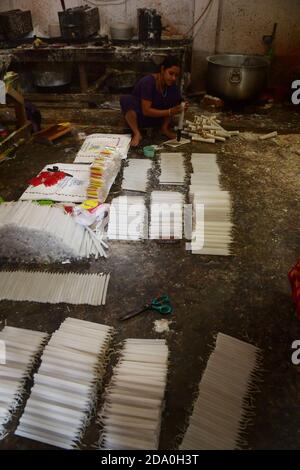 Die Arbeiter sind damit beschäftigt, vor dem Diwali-Festival Kerzen zu machen. Während Diwali, dem jährlichen hinduistischen Lichterfest, kaufen die Menschen Kerzen, um ihre Häuser zu schmücken. Agartala, Tripura, Indien. Stockfoto