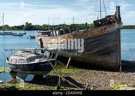 Zwei vernachlässigte Boote in Chichester Harbour am Ufer des Dell Quay, in der Nähe von Chichester, West Sussex, England, Großbritannien Stockfoto