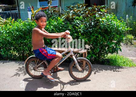 Palmen Sie und Teen jungen Radfahrer an der Route de Ceinture, Tahiti Nui, Gesellschaftsinseln, Französisch-Polynesien, Südsee. Stockfoto