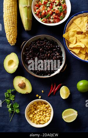Zutaten zum Kochen von Chilaquiles - schwarze Bohnen, Tortilla-Chips, Mais und Salsa Stockfoto