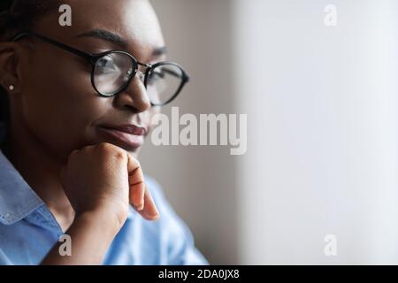 Nahaufnahme Indoor Portrait Of Black Female Business Analyst In Brillen, Seitenansicht Stockfoto