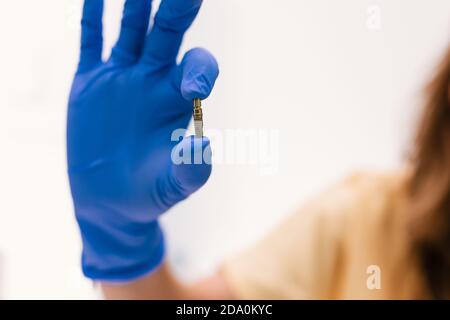 Zahnarzt hält ein Implantat mit den Fingern Stockfoto