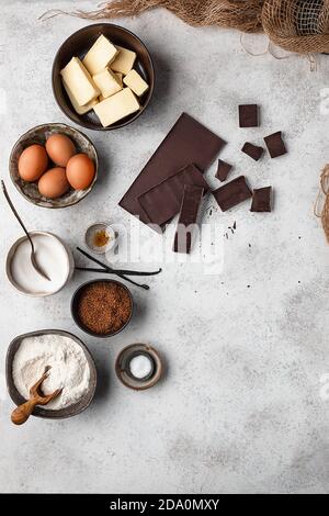 Draufsicht Set aus verschiedenen Zutaten für traditionelle Brownie-Kuchen Rezept auf grauem Marmortisch angeordnet Stockfoto