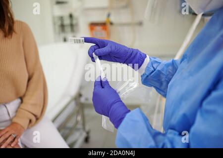 Von oben der Ernte nicht erkennbar Arzt in Uniform mit Impfstoff Röhre in der Nähe einer Patientin im Krankenhaus Stockfoto