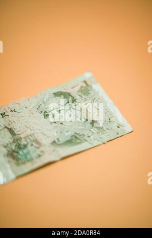 Draufsicht auf den chinesischen Renminbi, der unter Reishaufen gelegt wurde Auf Pfirsich Hintergrund im Studio Stockfoto