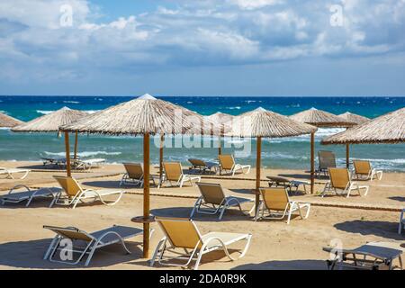 Sandstrand ohne Menschen mit Sonnenliegen und Strohschirm auf der Insel. Quarantäne aufgrund der Pandemie Stockfoto