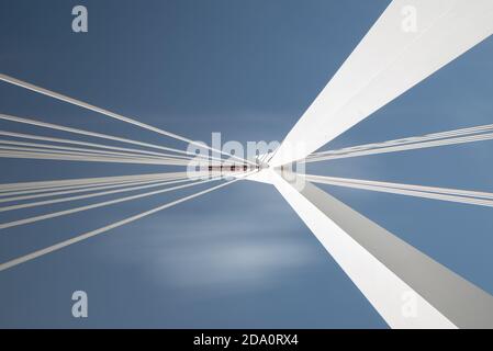 Von unten von weißen zeitgenössischen Hängebrücke mit hoher Säule Verbinden vieler Kabel mit blauem Himmel Stockfoto