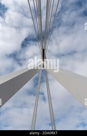 Von unten von weißen zeitgenössischen Hängebrücke mit hoher Säule Verbinden vieler Kabel mit blauem Himmel Stockfoto