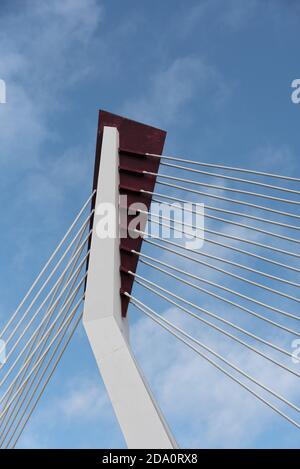 Von unten von weißen zeitgenössischen Hängebrücke mit hoher Säule Verbinden vieler Kabel mit blauem Himmel Stockfoto