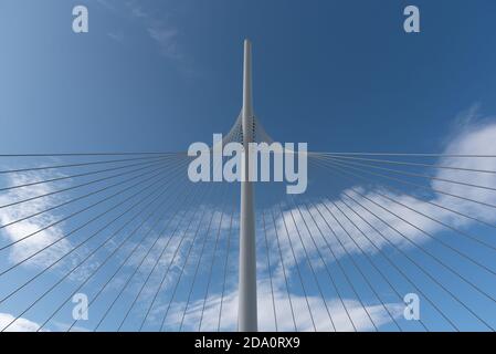 Von unten von weißen zeitgenössischen Hängebrücke mit hoher Säule Verbinden vieler Kabel mit blauem Himmel Stockfoto