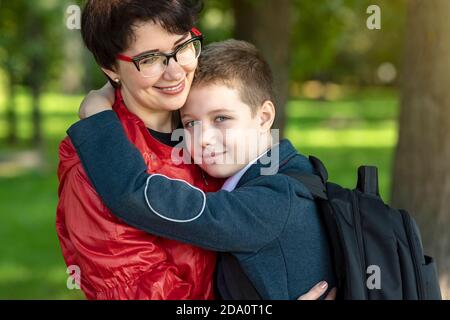 Glückliche Mutter und Sohn umarmen einander. Mütterliche Liebe, Elternschaft, familiäre Beziehungen des Vertrauens. Stockfoto