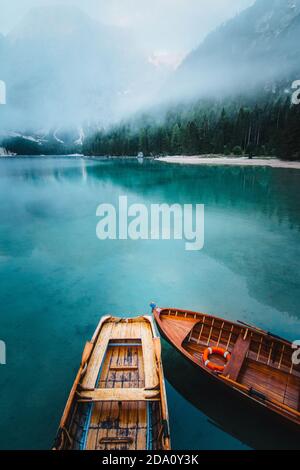 Von oben Holzboot mit Paddeln schwimmend auf türkisfarbenem Wasser Von ruhigen See auf dem Hintergrund der majestätischen Landschaft des Hochlandes Stockfoto