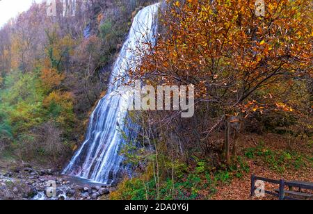 Orangenblätter und Wasserfall im Herbst - Valsassina, Lecco, Italien Stockfoto