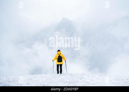 Rückansicht des anonymen Wanderers mit Wanderstöcken Schneebedeckter Boden in den Pyrenäen in Andorra Stockfoto