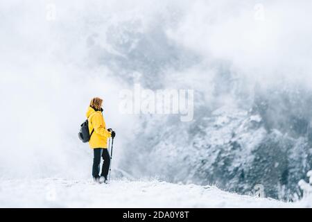 Seitenansicht des anonymen Wanderers mit Wanderstöcken Schneebedeckter Boden in den Pyrenäen in Andorra Stockfoto