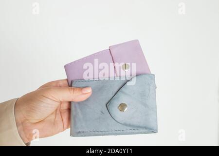 Gruppe bunte Geldbörse aus Leder Haut auf weißem Hintergrund.zwei modische moderne Leder Tasche Brieftaschen in der Hand, Nahaufnahme, Messing Druckknöpfe, neutrale Farben Stockfoto