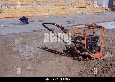 Rüttelplattenverdichter Maschine auf einer Baustelle. Ausrüstung für Bodenthrombose. Verdichtungsarbeiten auf Sand, Erde oder Asphalt Stockfoto