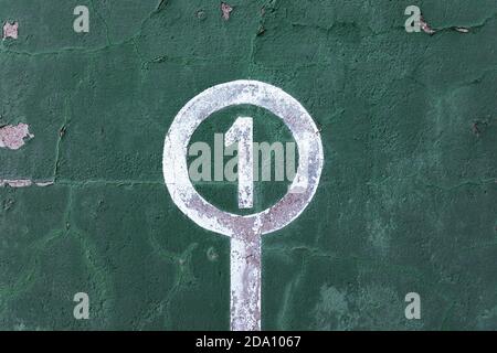 Verwitterte grüne Wand mit abblätternder Farbe und Nummer eins Konzept des Gewinners Stockfoto