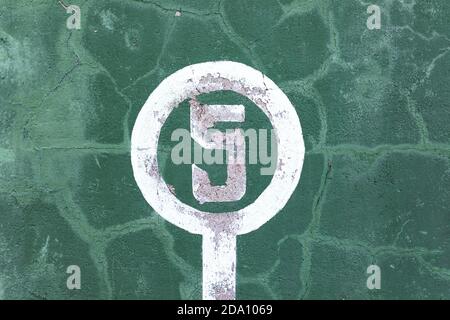 Verwitterte grüne Wand mit abblätternder Farbe und Nummer fünf Konzept des Gewinners Stockfoto