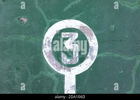 Verwitterte grüne Wand mit abblätternder Farbe und Nummer drei Konzept des Gewinners Stockfoto