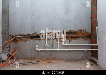 Installation der Wasserversorgung Verlegung von Rohren in die Wand. Kalt- und Warmwasser-Versorgung in der Wohnung Stockfoto