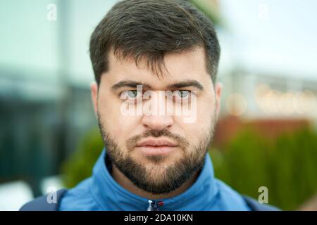 Junge weiße bärtige attraktiven Mann mit ernst aussehen im Freien. Stockfoto