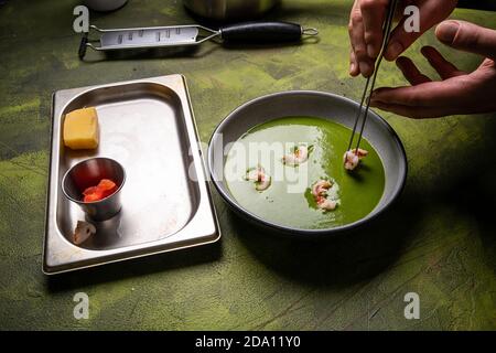 Der Koch kocht Pommes frites Nudeln mit Garnelen und Gemüse. Kochen von Speisen Stockfoto