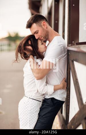 Glückliche junge Mann und Frau mit Spaß im Freien an einem warmen Sommertag. Paar umarmt in der Nähe Pferd rancho Stockfoto