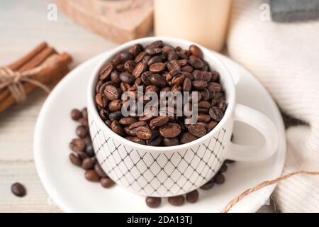 Kaffeebohnen in einer Tasse Nahaufnahme auf einem hellen Hintergrund. Stockfoto