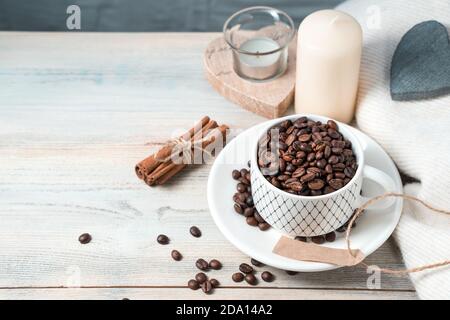 Kaffeebohnen in einer weißen Keramikschale auf einem Holzhintergrund. Stockfoto