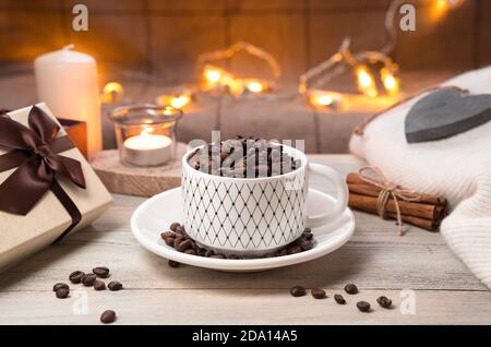 Kaffee- und Geschenkbox auf festlichem Hintergrund mit brennender Girlande. Stockfoto