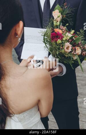 Braut liest ihre Gelübde an den Bräutigam während der offiziellen Trauung. Hochzeitsagentur Konzept. Stockfoto