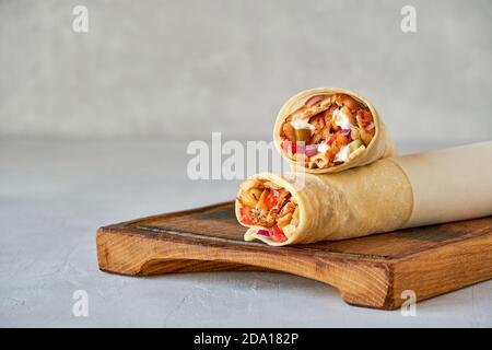 Shawarma mit Huhn und Knoblauchsauce auf Holzbrett. Nahaufnahme Stockfoto