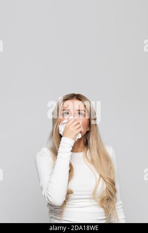 Studio Portrait von ungesunde Frau mit Serviette weht Nase, Blick auf die Quelle der Allergie. Speicherplatz kopieren Stockfoto