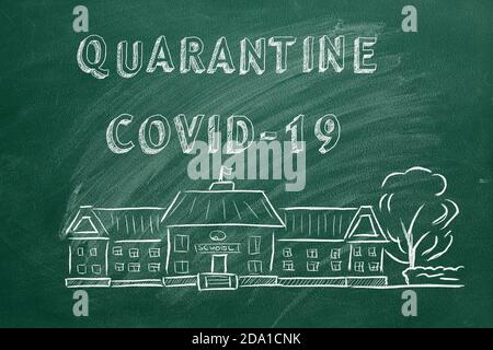 Schulgebäude und Schriftzug Quarantine COVID-19 auf grüner Tafel. Handgezeichnete Skizze. Coronavirus-Konzept. Stockfoto