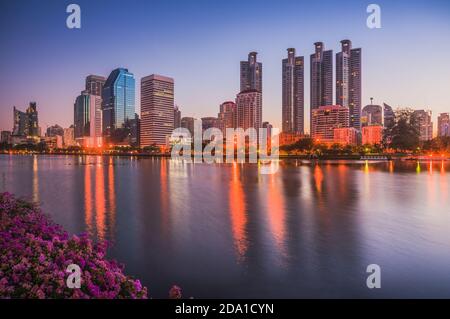 Lake in City Park unter Wolkenkratzern in Twilight. Benjakiti Park in Bangkok, Thailand Stockfoto