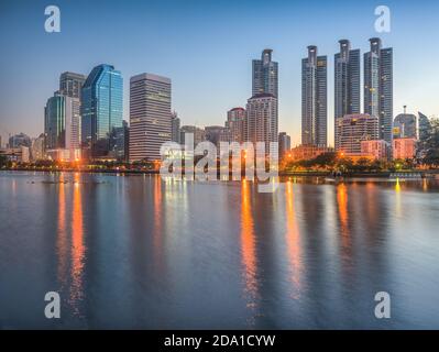 Lake in City Park unter Wolkenkratzern in Twilight. Benjakiti Park in Bangkok, Thailand Stockfoto