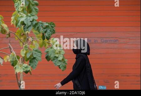 Mashhad, Iran. November 2020. Eine Frau mit Gesichtsmaske kommt an einem geschlossenen Laden in Mashhad, Iran, vorbei, 7. November 2020. Der Iran meldete am Sonntag 459 Todesfälle im Zusammenhang mit COVID-19, was ihn zur höchsten täglichen Todesrate seit dem Ausbruch des Virus im Land macht. 682,486 COVID-19 Fälle wurden bisher im Iran bestätigt, nach der Registrierung von 9,236 Infektionen. Quelle: Ahmad Halabisaz/Xinhua/Alamy Live News Stockfoto