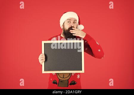 Unglaublich. Winter Ankündigung. Winter event. Winterurlaub. Santa Claus hat mit Werbung. Schwarzes Brett für Informationen. Mann leere Tafel kopieren. Guy santa claus roten Hintergrund. Stockfoto