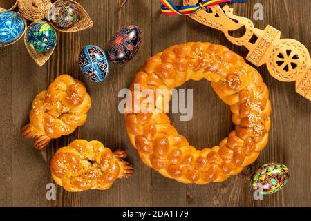 Osteuropäische geflochtene hausgemachte Brot mit traditionellen bemalten Eiern isoliert auf einem Holztisch. Stockfoto