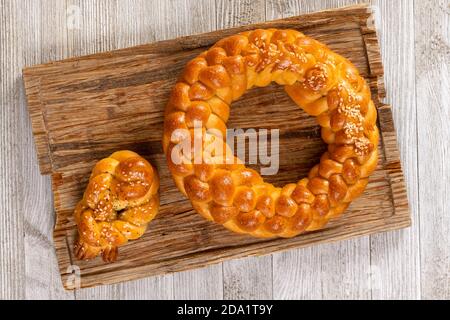 Osteuropäische Art geflochtenes hausgemachtes Weißbrot isoliert auf einem Holztisch. Stockfoto