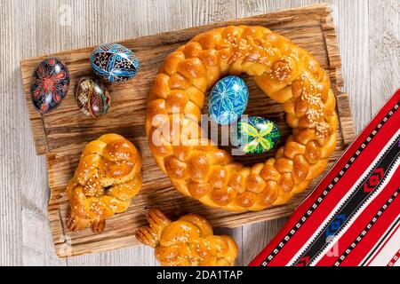 Osteuropäische geflochtene hausgemachte Brot mit traditionellen bemalten Eiern isoliert auf einem Holztisch. Stockfoto