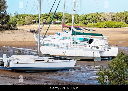 Mackay, Queensland, Australien - Oktober 2019: Gestrandete Boote auf Schlamm und Sand auf einem Bach bei Ebbe Stockfoto