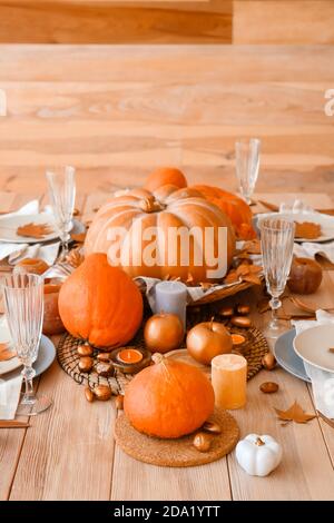 Schöne Tischkulisse mit Kürbissen und Herbstblättern beim Essen Zimmer Stockfoto