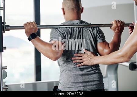 Doing Kniebeugen mit Langhantel Stockfoto