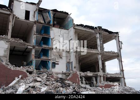 Blick auf den Abriss eines mehrstöckigen Gebäudes. Demontage und Abriss von Gebäuden und Strukturen. Beton zerstören Stockfoto