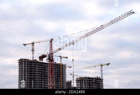 Turmdrehkrane auf großer Baustelle gegen blauen Himmel. Baukran. Schalungslösungen für Stahlbau und Rahmen superstr Stockfoto