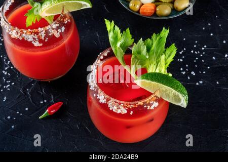 Bloody Mary Cocktail aus der Nähe. Tomatensaft und Alkohol mischen, garniert mit Limette und Sellerie Stockfoto