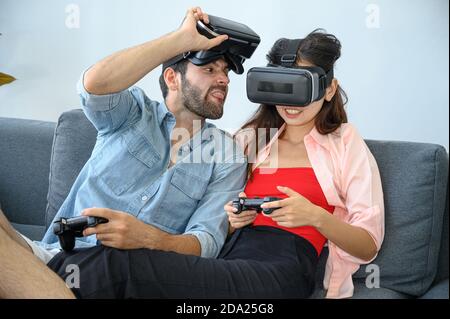 Paare Liebhaber genießen es, VR-Spiel zusammen zu Hause zu spielen. Familienbeziehungskonzept. Stockfoto