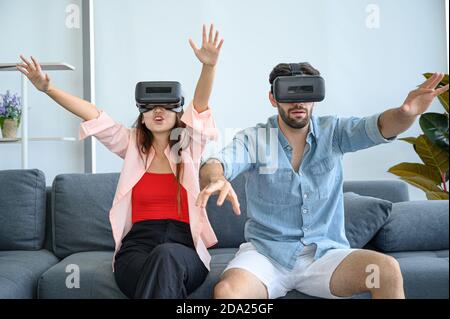 Paare Liebhaber genießen es, VR-Spiel zusammen zu Hause zu spielen. Familienbeziehungskonzept. Stockfoto